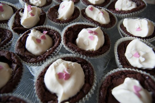 Brownie cupcakes with whipped cream and heart decorations