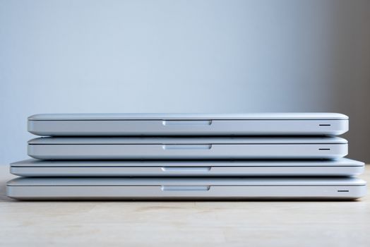 A bunch of aluminium laptops stacked on top of each other.