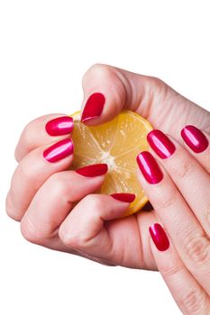 Hand with manicured nails painted a deep glossy red squeeze lemon on white background