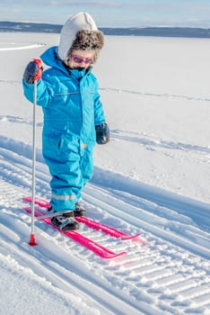 Young girl cross-country skiing. In snowmobile tracks.
