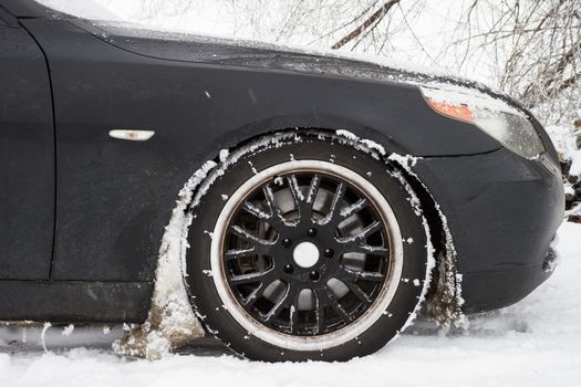 Car covered with snow on the wheels. 