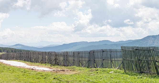 The idyllic landscape: view of the mountains behind the fence from the pass