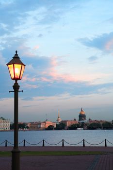 View of Saint Petersburg in Russia across Neva river at sunset with street lamp