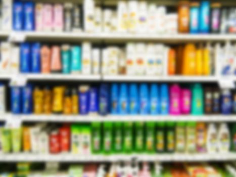 Blurred colorful supermarket products on shelves - Shampoo bottles background with shallow DOF