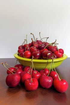 Bing Cherries in a green lime green bowl on a wood table