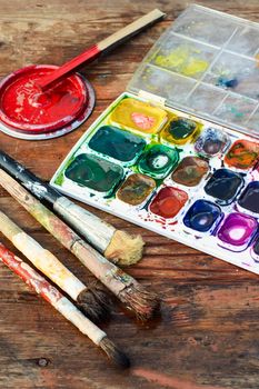 Set of watercolors and different brushes for painting on wood vintage palette