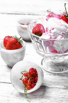Ice cream with strawberries and currants on light background.Photo in high key