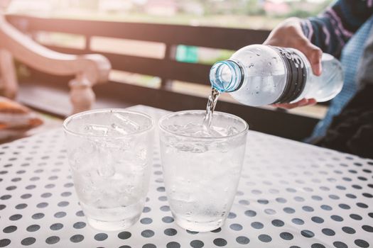 Glasses with ice cubes on black dot background table .