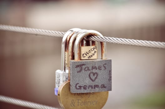 Padlock in the form of hearts hanging on the bridge next to the other locks.