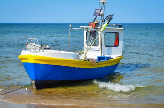 White yellow blue   fishing boat on alongshore
