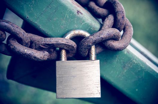 Rusty padlock on rusty chain