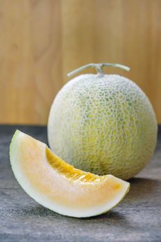 Ripe cantaloupe melon fruit on wooden background