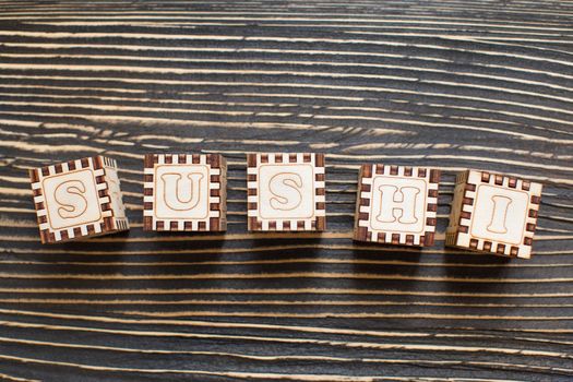 Wooden blocks with the English alphabet, sushi.