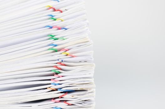 Pile overload document of report and receipt with colorful paperclip place on white background.