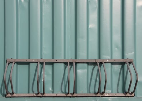 Empty Metal Bicycle Parking Rack Mount on Green Container