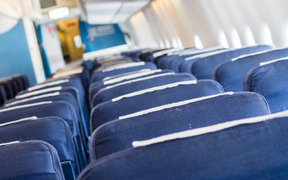 Empty old blue airplane seats in the cabin, selective focus