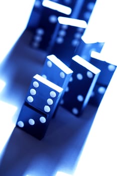 Black dominoes standing in a row on white background