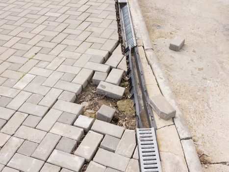 The destruction of the pedestrian walkway of paving with drainage and concrete road