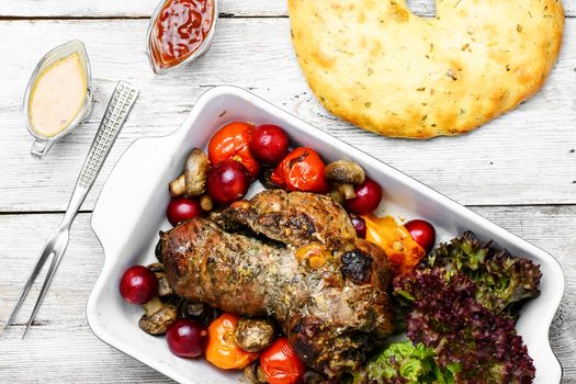 Twisted meatloaf with veal in plum sauce and vegetables in baking dish