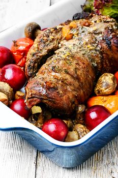 Cooking baking pan with the meat loaf of veal with vegetables and plum sauce