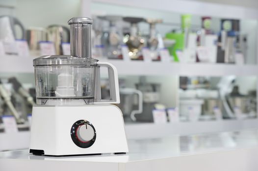 single electric food processor at retail store shelf, defocused background