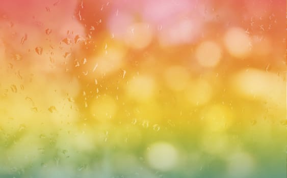 Abstract blurred background rain drop on glass mirror in fresh colourful summer orange pink and green bokeh