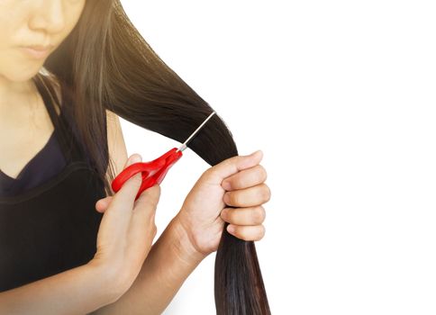 Focused to lady hand catch scissors cutting long hair on plain background and copy space