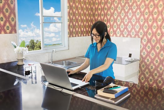 Relaxing life style Asian girl serfing internet or data search on notebook at counter in home 