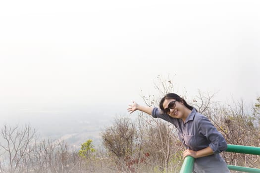Asian lady smiling and relax on highland top view seeing point with nature background