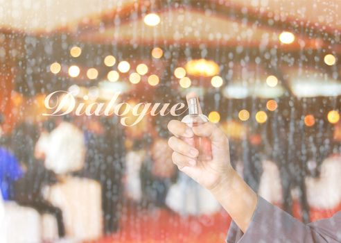 Business women hand holding perfume bottle  spraying text dialogue on waterdrop glass window with blurred people meeting in convention room background 