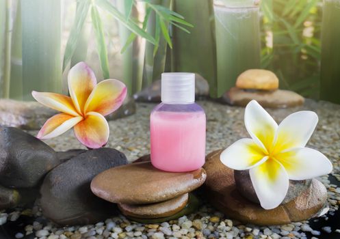 Bubble bath and shower gel liquid with flowers on green bamboo tree and nature relaxing feeling background