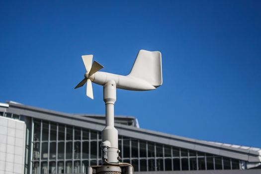 Close up of the anemometer on top of the pole against the clear blue sky