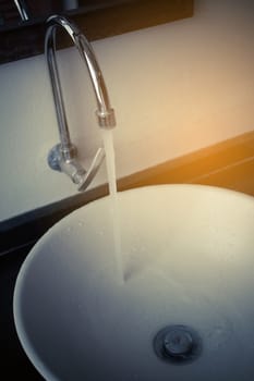 Water tap over white ceramic washbasin