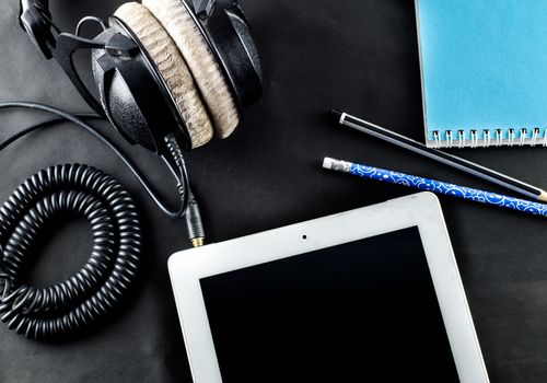 blank notebook in top view with music concept 
Black background headphones