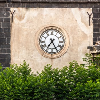 Antique clock placed a facade of a Sicilian baroque church