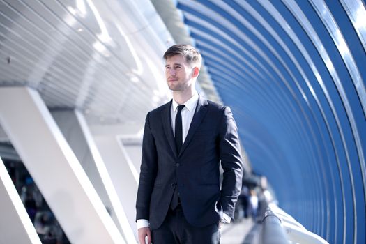 Young Businessman standing in corridor of modern office building