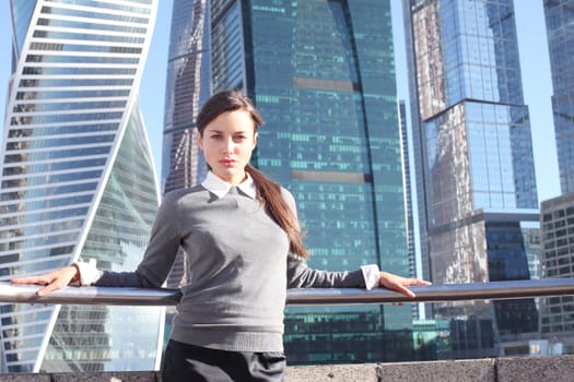 Young beautiful businesswoman outdoors at skyscraper background