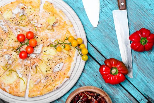 Meat delicious pizza with cherry tomatoes on wooden tray and hot spices