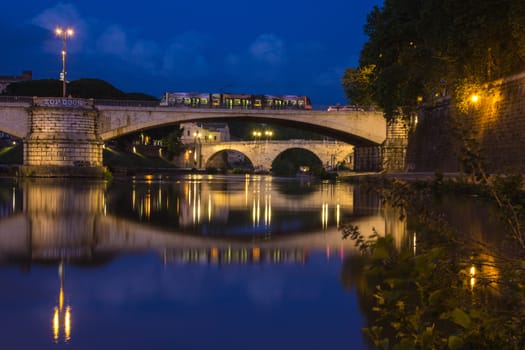 Double bridge reflections (Trastevere district) on the River Tiber, Rome, Italy