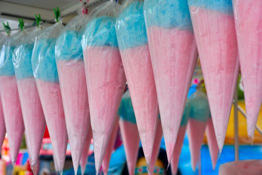 Candy floss, pink and blue found in an amusement park.