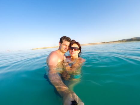 Middle age couple having fun in the water summertime holidays in Egypt. Couple in love shooting selfie photo. Woman with sunglasses