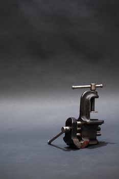 Old metal vise on dark background with free space for text