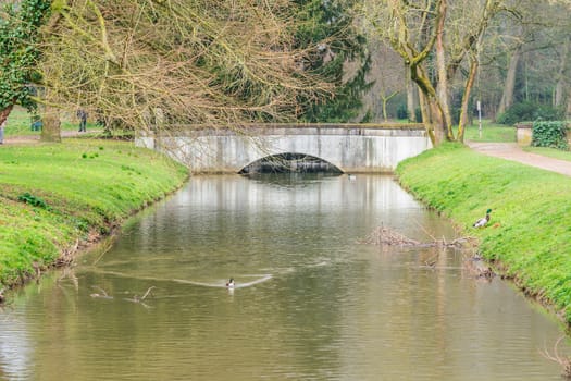 Small concrete bridge over a water jump with ducks.