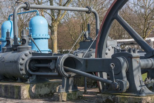 Old industrial sewing machine, water turbine on a concrete base.