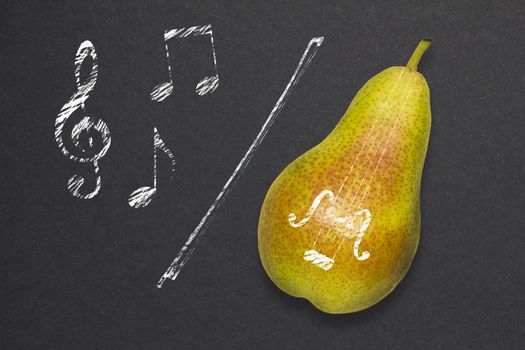 Creative concept photo of a pear as a violin with illustrated bow and notes on black background.