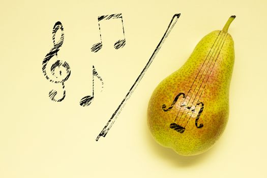 Creative concept photo of a pear as a violin with illustrated bow and notes on yellow background.