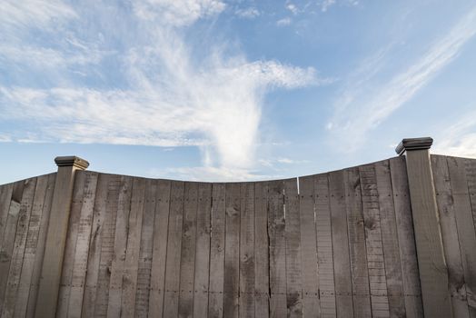 A section of vertical, overlapped wooden garden fence in closeup in the sun with shadows