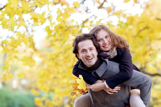 Happy smiling couple hugging in autumn park