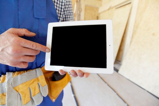 Construction worker pointing at digital tablet close-up