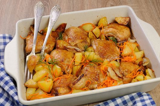 Braised roast chicken and vegetables in ceramic roasting pan